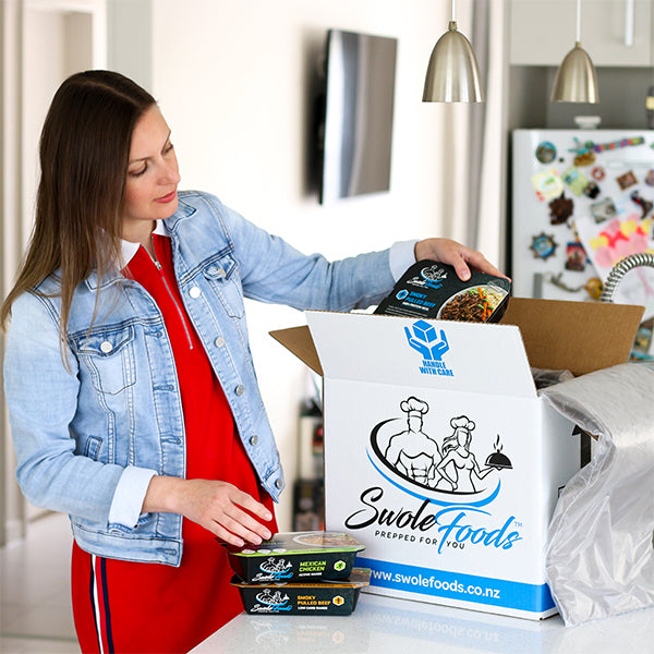 Woman opening meal subscription delivery SwoleFoods Auckland New Zealand
